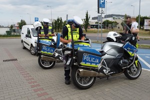 na zdjęciu policjanci przy motocyklach, za nimi samochód