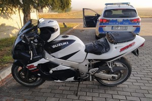 na zdjęciu motocykl na parkingu i obok radiowóz
