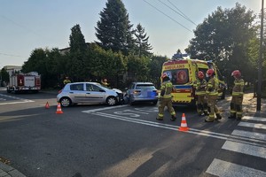 na zdjęciu dwa rozbite samochody i obok karetka pogotowia