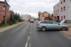 na zdjęciu dwa rozbite samochody na jezdni, radiowóz, wozy strażackie i osoby