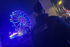 na zdjęciu policjant niedaleko wielkiego białego młyna po zmroku