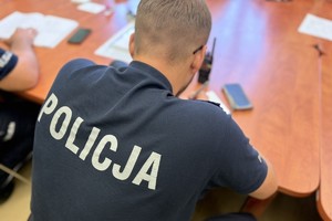 na zdjęciu policjant siedzący przy stole