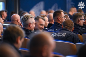 na zdjęciu policjanci na widowni tyłem do obiektywu