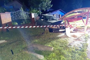 na zdjęciu samochód przy ogrodzeniu i zdemolowanej wiacie przystankowej