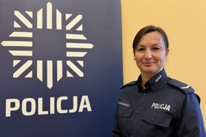 na zdjęciu dzielnicowa Piotrowska przy banerze z napisem policja