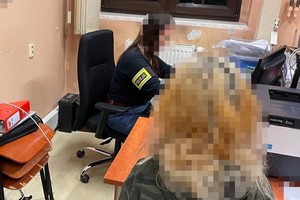 na zdjęciu nieletnia przy biurku, przy którym siedzi policjantka z opaską na ramieniu