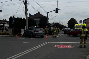 na zdjęciu rozbite pojazdy na drodze, strażacy i policjanci