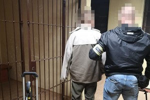 na zdjęciu zatrzymany z policjantem obok celi