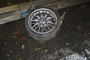 na zdjęciu urwane koło z samochodu na asfalcie przy barierach energochłonnych