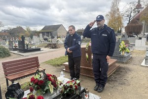 na zdjęciu zastępca komendanta i kapelan Policji przy grobie na cmentarzu