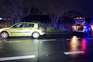 na zdjęciu samochód i radiowóz na jezdni po zmroku