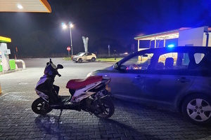 na zdjęciu nieoznakowany radiowóz, obok motorower