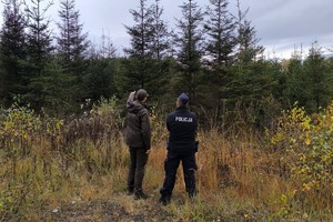 na zdjęciu policjant i strażnik leśny na terenie leśnym