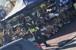 na zdjęciu policjant przy namiotach ze zniczami