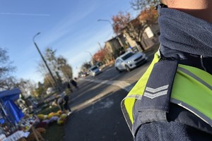 na zdjęciu fragment policyjnego munduru, za nim droga