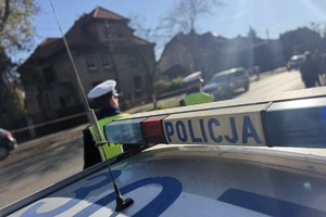 na zdjęciu policjanci przy drodze i radiowóz