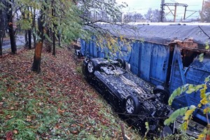 na zdjęciu samochód osobowy na dachu obok wagonu kolejowego