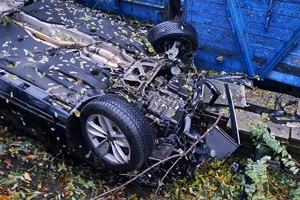 na zdjęciu samochód osobowy na dachu obok wagonu kolejowego