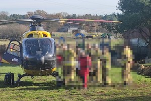 na zdjęciu śmigłowiec ratunkowy, obok zblurowane sylwetki ratowników i strażaków