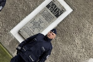 na zdjęciu policjant pod pamiątkową tablicą