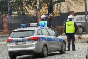 na zdjęciu policjanci przy radiowozie