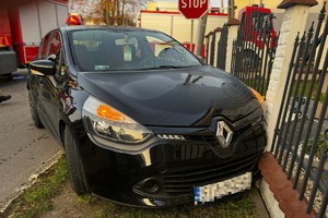 na zdjęciu samochód z uszkodzeniami przy ogrodzeniu posesji