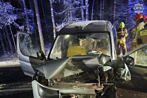Na zdjęciu rozbity pojazd na jezdni obok strażacy