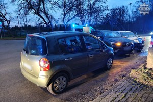 Na zdjęciu trzy pojazdy biorące udział w zdarzeniu drogowym za nimi radiowóz na sygnałach