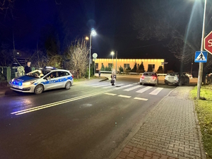 na zdjęciu radiowóz przy przejściu dla pieszych, obok na jezdni inne samochody i osoby