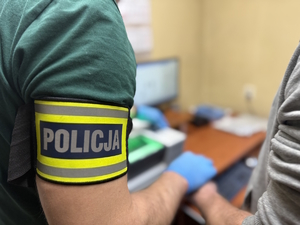 na zdjęciu opaska policyjna na ramieniu nieumundurowanego policjanta