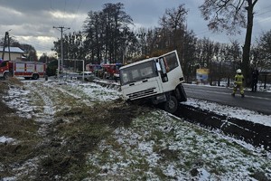 na zdjęciu samochód ciężarowy w rowie, za nim wozy strażackie