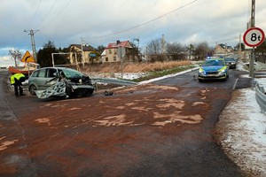 na zdjęciu rozbity samochód osobowy na jezdni, obok radiowóz policyjny