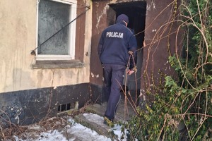 na zdjęciu policjant wchodzący do budynku