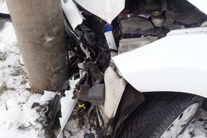 na zdjęciu samochód z uszkodzeniami wbity w słup i ogrodzenie