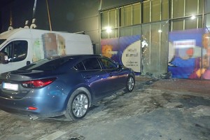 na zdjęciu samochód przed uszkodzoną witryną sklepową