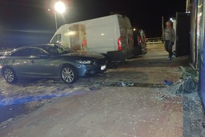 na zdjęciu samochód przed uszkodzoną witryną sklepową