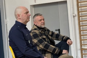 na zdjęciu aktor i policjanta siedzący na krzesłach w sali