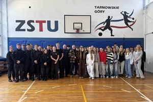 grupowe zdjęcie uczniów, nauczycieli, policjanta i aktora w sali