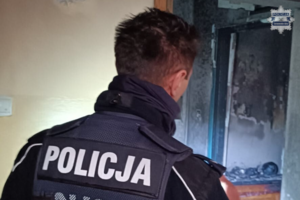 Na zdjęciu policjant wewnątrz spalonego mieszkania