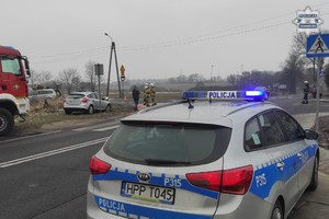 Na zdjęciu radiowóz obok fragment wozu strażackiego a przed nim Pojazdy biorące udział w zdarzeniu