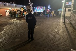 na zdjęciu policjantka przed małym rynkiem w Kaletach