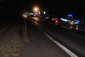 na zdjęciu droga po zmroku, na której stoją pojazdy