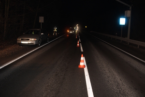 na zdjęciu droga po zmroku, na której stoją pojazdy