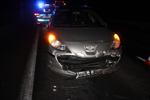 na zdjęciu droga po zmroku, na której stoją pojazdy