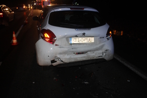 na zdjęciu droga po zmroku, na której stoją pojazdy