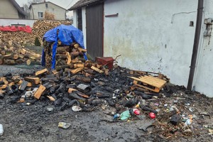 na zdjęciu nadpalone drewno opałowe przy budynku