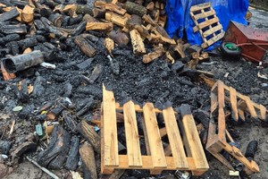 na zdjęciu nadpalone drewno opałowe przy budynku