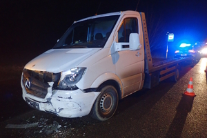 na zdjęciu laweta z uszkodzonym przodem, za nią radiowóz