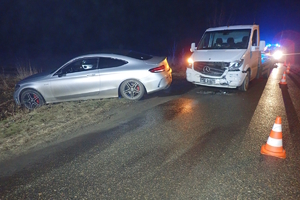 na zdjęciu samochód w poprzek drogi przy poboczu, za nim uszkodzona laweta