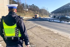 na zdjęciu policjant przy drodze